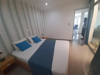 a bedroom with a large bed with blue pillows at Apto T1 Comfort in Praia