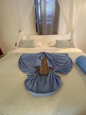 a blanket on a bed with a stuffed animal on it at Nos Kasa in Sal Rei