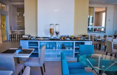 a dining room with blue chairs and a counter at Tiduca Hotel in Ponta do Sol