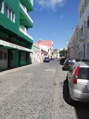 a street with cars parked on a cobblestone street at Casa da Luz - Appartement in Mindelo