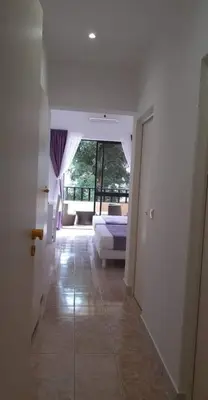 a hallway with a room with a bed and a window at Aparthotel Santa Maria Beach in Santa Maria