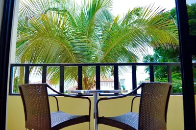 a table and chairs on a balcony with a palm tree at Aparthotel Santa Maria Beach in Santa Maria