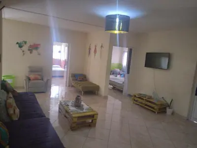 a living room with couches and a tv at Meeting Point Hostels-Tarrafal Center, also in Praia & Fogo-NO CASH ACCEPTED in Tarrafal