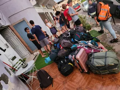 a group of people standing around a pile of luggage at Meeting Point Hostels-Tarrafal Center, also in Praia & Fogo-NO CASH ACCEPTED in Tarrafal