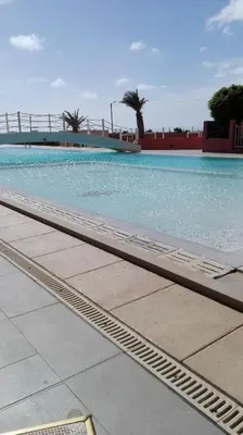 a swimming pool with blue water and a bridge at PORT DO SOL-free wi-fi no limits in Sal Rei