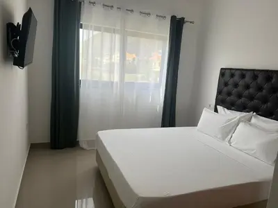 a bedroom with a white bed and a window at Tarrafal Guest House in Tarrafal