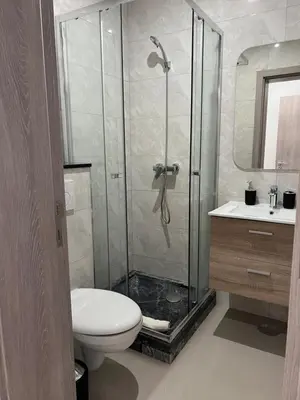 a bathroom with a shower with a toilet and a sink at Tarrafal Guest House in Tarrafal