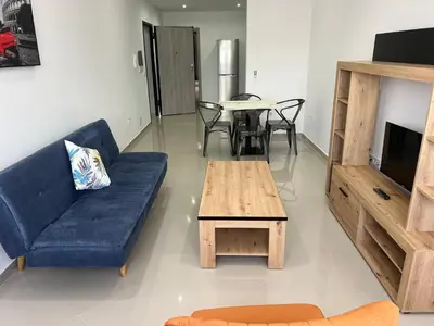 a living room with a blue couch and a table at Tarrafal Guest House in Tarrafal