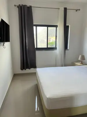 a bedroom with a white bed and a window at Tarrafal Guest House in Tarrafal