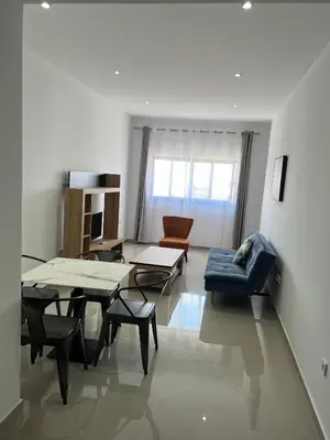 a living room with a couch and a table and chairs at Tarrafal Guest House in Tarrafal