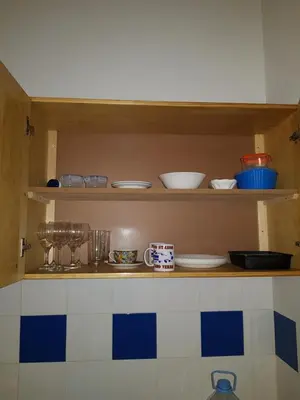 a kitchen shelf with bowls and dishes on it at Casa Azul One Rua da Morna Santa Maria in Santa Maria