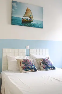 a bedroom with a bed with a picture of a sail boat at IMOBITUR-Tourist Apartments- Palmarejo Centro AV SV in Praia