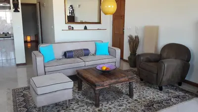 a living room with a couch and a chair and a table at Bouganville in Mindelo
