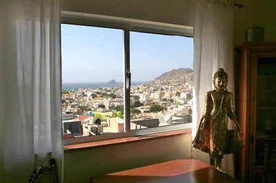 a statue in front of a window with a view at Bouganville in Mindelo