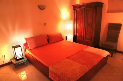 a bedroom with a bed and a dresser and a mirror at Bouganville in Mindelo
