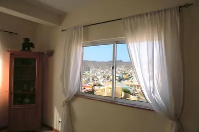a window in a room with a view of a city at Bouganville in Mindelo