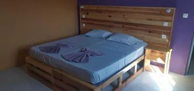a bed with blue sheets and a wooden headboard at casa alcindo in Portela