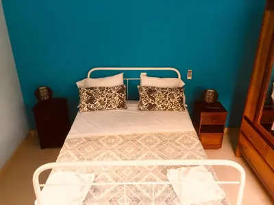 a bed in a room with a blue wall at Casa Santa Barbara Deluxe in Ribeira Grande