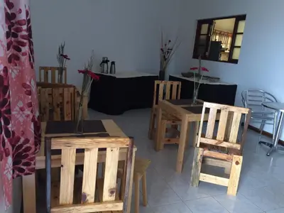 a living room with wooden chairs and a table at Vannilla Residencial in Mindelo