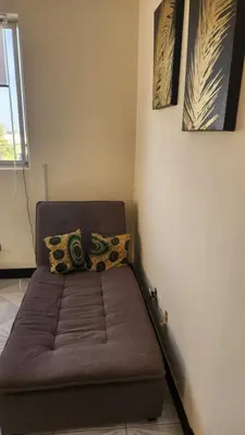 a bed in a room with two pictures on the wall at Meeting Point Hostels-Praia Beachwalk-NO CASH ACCEPTED-Also in Fogo & Tarrafal in Praia