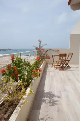 a balcony with flowers and a view of the beach at Ca Marta Penthouse in Sal Rei