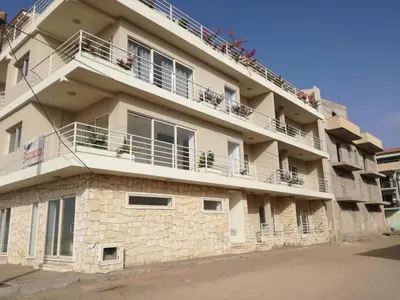a building with people sitting on the balconies of it at Ca Marta Penthouse in Sal Rei