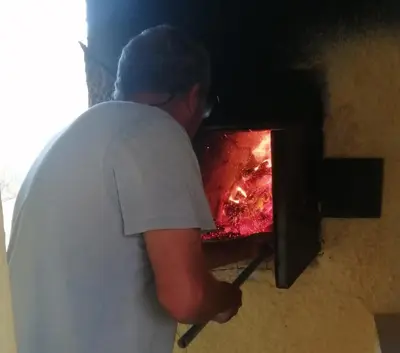 a man is standing next to a fire oven at Barracudamaio in Morro