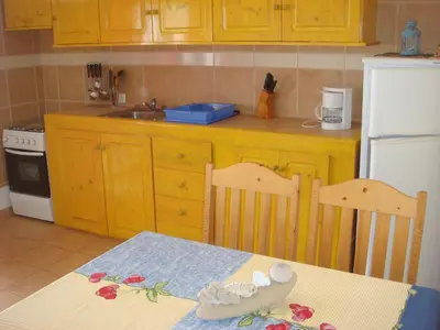 a kitchen with yellow cabinets and a table with a table sidx sidx sidx at Barracudamaio in Morro