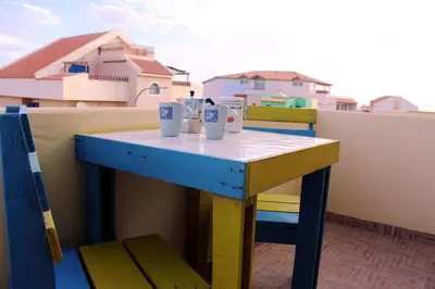 a blue table on a balcony with two cups on it at Santa Maria flats in Santa Maria