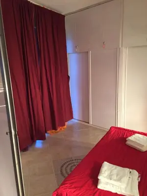 a bedroom with a red bed and a red curtain at Santa Maria flats in Santa Maria