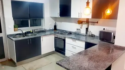 a kitchen with black and white cabinets and a sink at Elegant Modern Apartment with AirCond in Praia