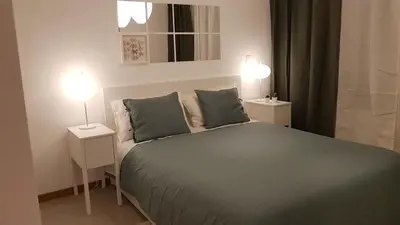 a bedroom with a large bed with two night stands at Elegant Modern Apartment with AirCond in Praia