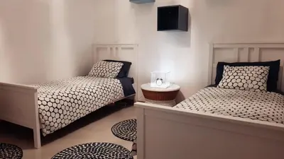 a bedroom with two beds and a night stand at Elegant Modern Apartment with AirCond in Praia