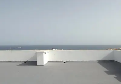 a white bench sitting on top of a roof at Elegant Modern Apartment with AirCond in Praia