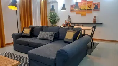 a living room with a blue couch and a table at Elegant Modern Apartment with AirCond in Praia
