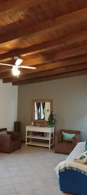a living room with a ceiling fan and a mirror at Ca' Greta - Big apartment close Estoril beach in Sal Rei