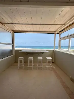 a room with a table and stools in front of a window at Vista Do Mar Sea View WI-FI FREE Sal Rei in Sal Rei