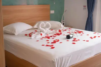 a bed with red roses and two white rabbits and a pile thereof at Blue Marlin Hotel in Mindelo