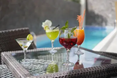 a table with four drinks on a glass table at Blue Marlin Hotel in Mindelo