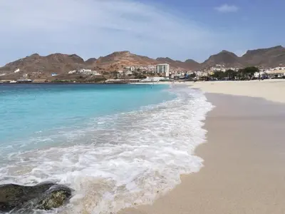 a beach with blue water and mountains in the background at Private Apartament Celestina & Carlos in Mindelo