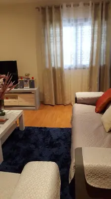 a living room with a couch and a table and a window at Private Apartament Celestina & Carlos in Mindelo