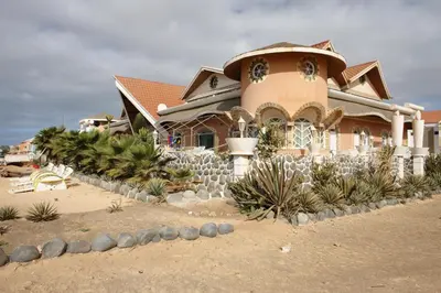 a house with a bunch of plants in front of it at Residencial Cabo Verde Palace in Santa Maria