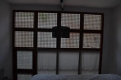 a bedroom with a window with white curtains and a bed at Studio M in Mindelo
