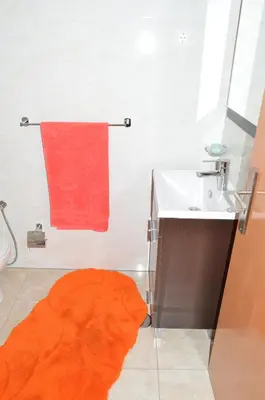an orange rug on the floor of a bathroom with a sink at House Gonçalves in Praia