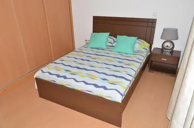 a bed with two green pillows in a bedroom at Apartamento Augusto in Praia