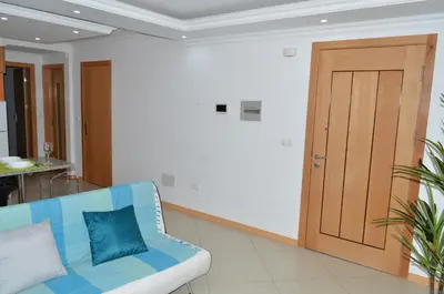 a living room with a blue couch and a wooden door at Apartamento Augusto in Praia