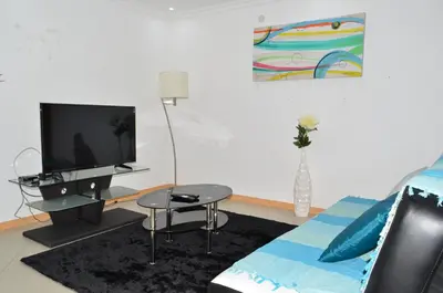 a living room with a bed and a tv at Apartamento Augusto in Praia
