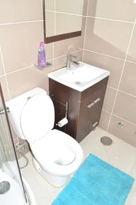 a bathroom with a toilet and a sink and a mirror at Apartamento Augusto in Praia