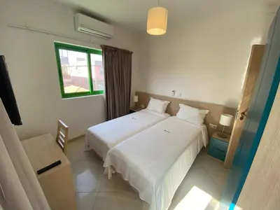 a bedroom with two white beds and a window at ApartHotel NhaTerra in Santa Maria