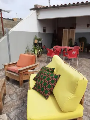 a yellow couch sitting on a patio with tables and chairs at Mix 2 in Mindelo